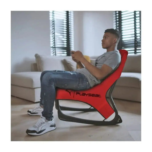 Active Tilting Gaming Chair Red with a gamer seated in a living room, Playseat branding visible.