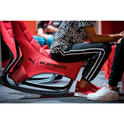 Red and black puma playseat racing chair with a sleek, sporty design.